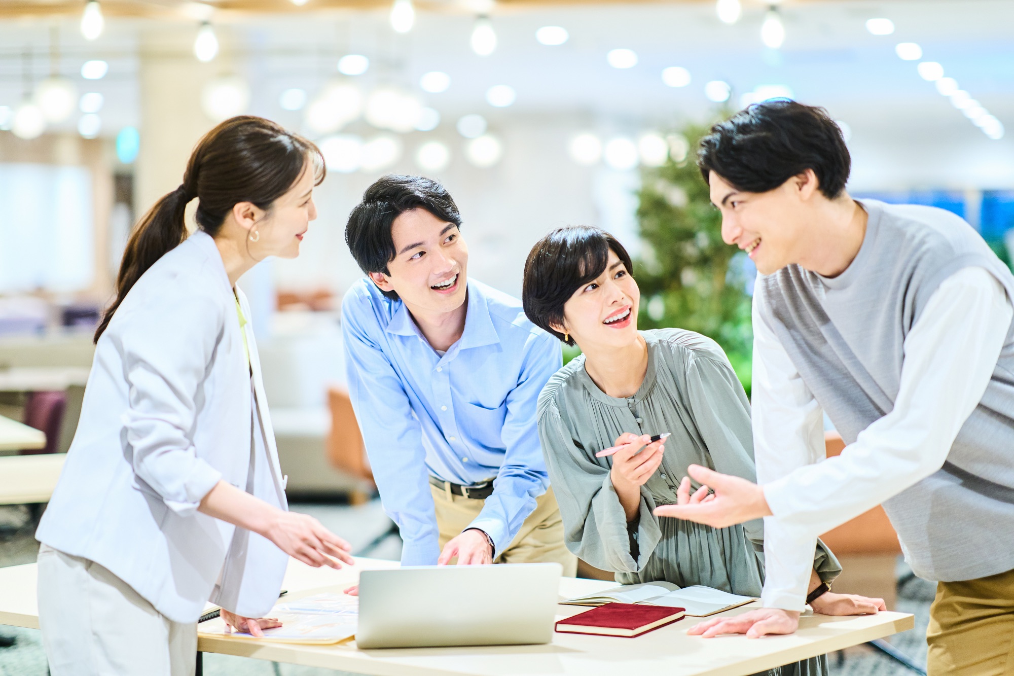 明るいオフィスで活発に議論する多様なチーム